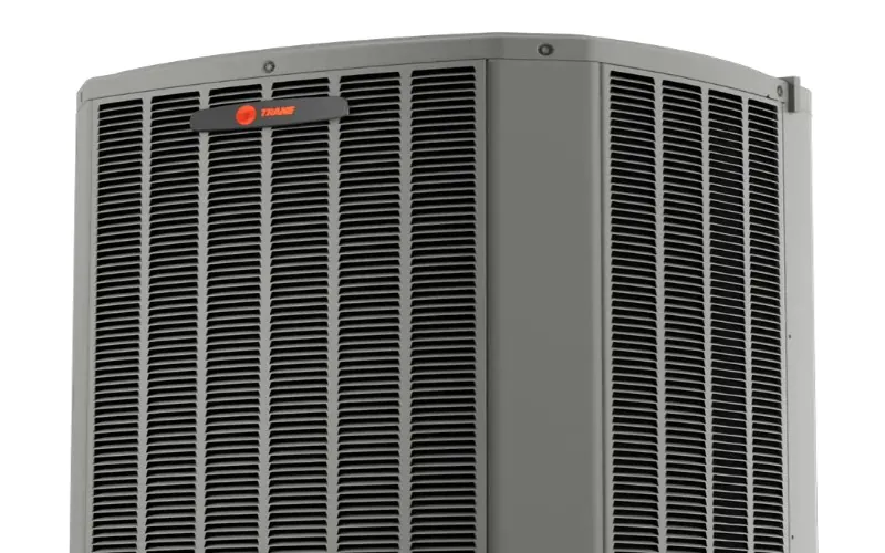 HVAC technician looking at a tablet next to an outdoor AC unit