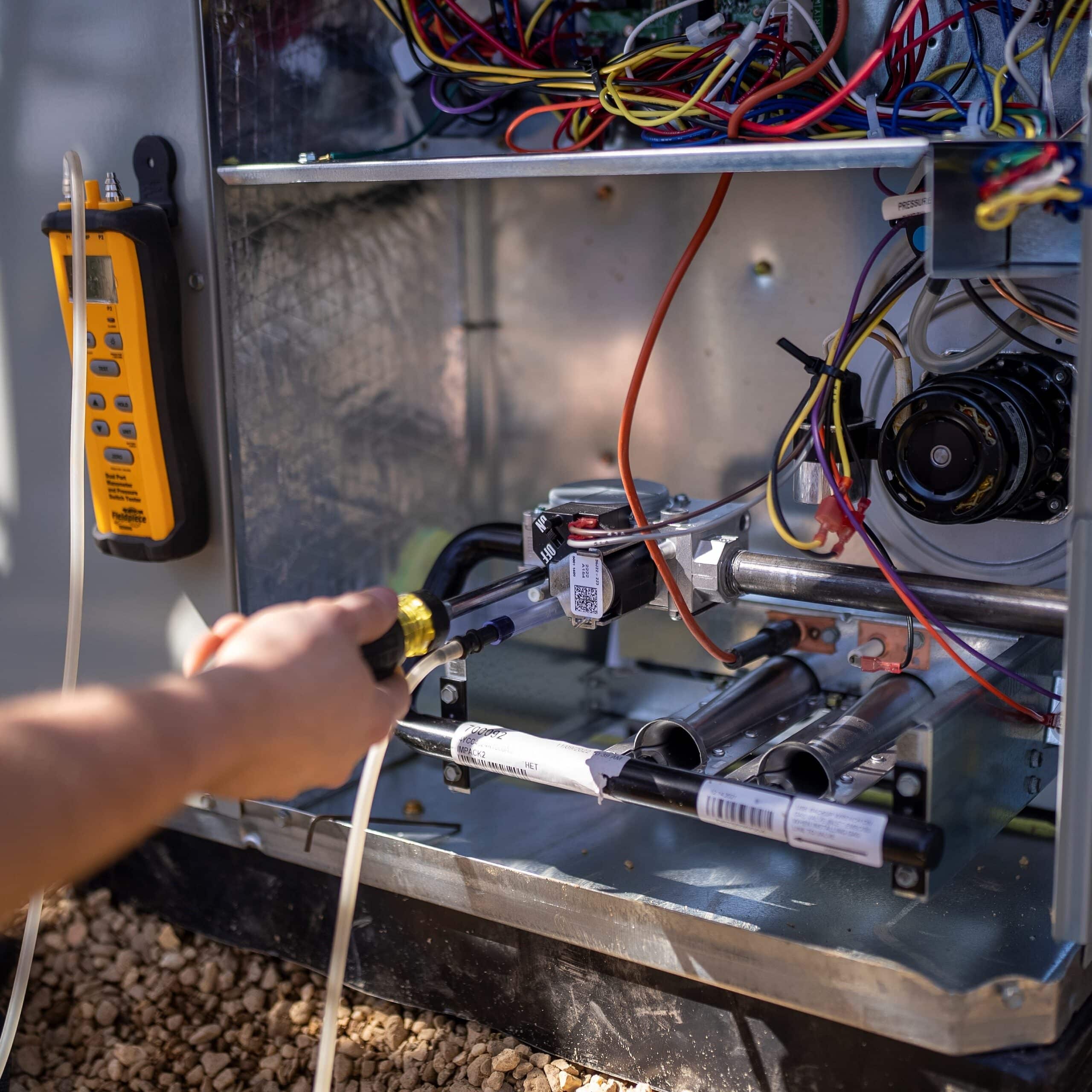 Technician using a screwdriver while working on a heat pump