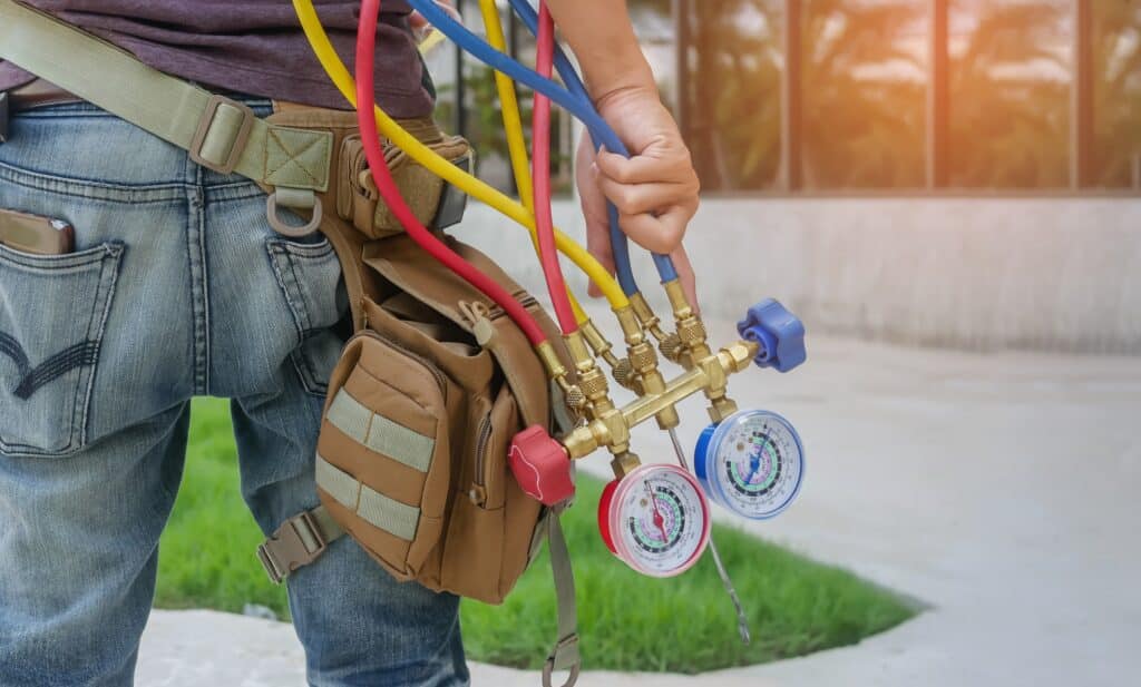 HVAC technician holding manifold gauges