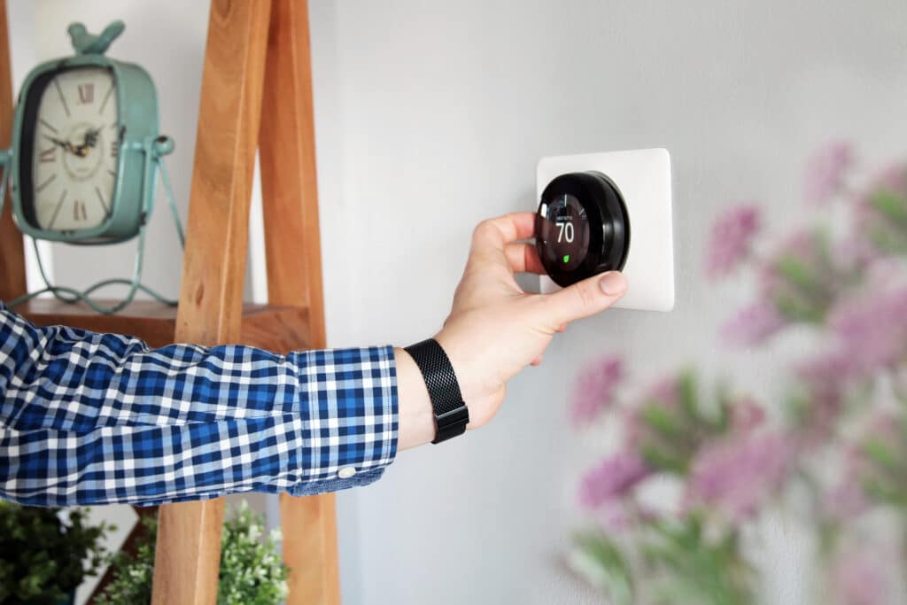 homeowner adjusting smart thermostat