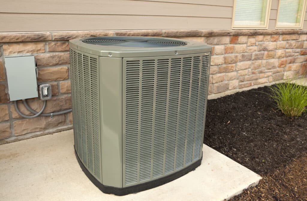 Central air conditioner on a concrete pad outside of a home